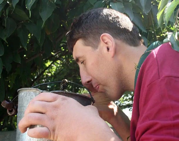 Man drinking from a Bucket