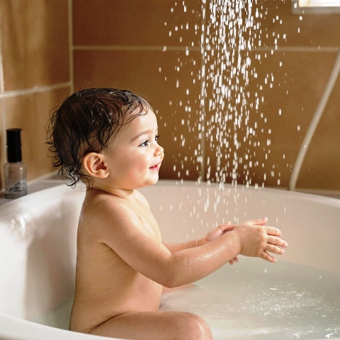 A photo of a child enjoying a shower of clean soft water